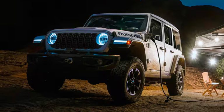 2025 Jeep Wrangler 4xe on rugged terrain showing plug-in hybrid trail-ready stance