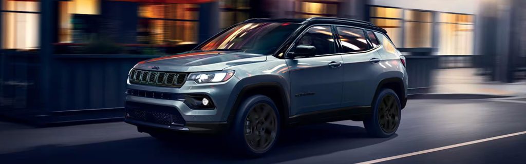2026 Jeep Compass driving through city streets at night
